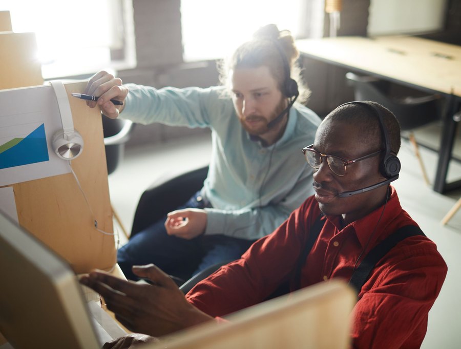 Two operations team members reviewing load data and metrics at a dispatch desk